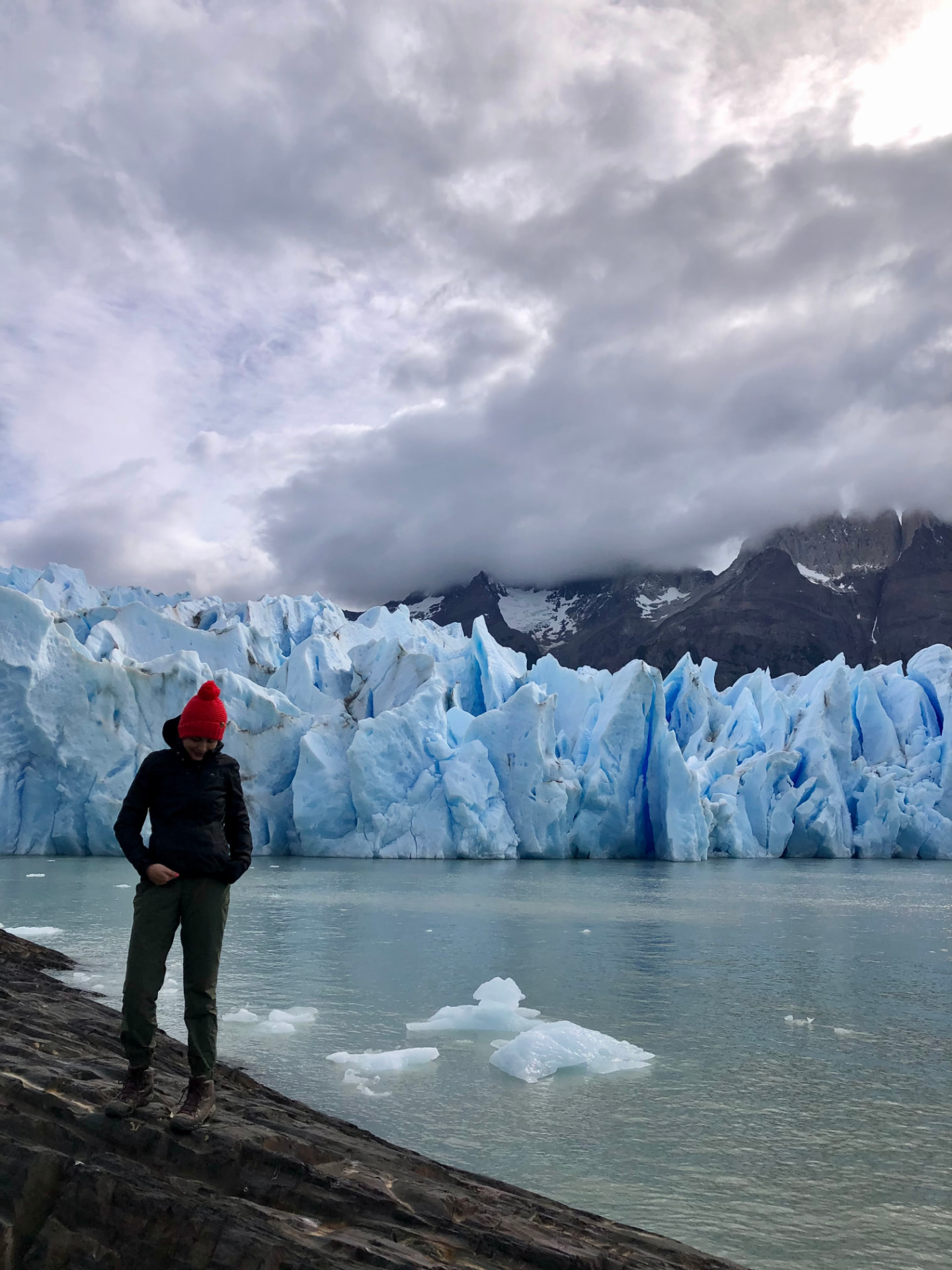 Standing in front of the blue ice of Grey Glacier in Patagonia